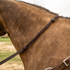 Braided latigo barrel rein with a braided knot lying across the neck of a buckskin horse. The dark braided section joins a flat latigo strap that runs toward the bit.