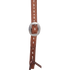 Cart buckle on a chestnut buckstitched headstall cheek, seen up close. White buckstitch lacing runs down the center of the strap between rows of white stitching.