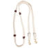 White blended mohair barrel rein, coiled and seen from above. The braided mohair rein has dark latigo leather knots along both sides and ends in buckles with snaps, made by Martin Saddlery for barrel racing.