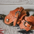 Oak leaf spur straps on a pair of spurs resting on a woven blanket by a whitewashed wall. Acorn oak tooling covers the natural leather, with buckles across the top.