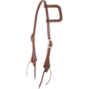 Weathered antique slip ear headstall, seen from the front quarter. The skirting leather has a weave stamp on the ear loop and shaped cheek ends, with cart buckles and latigo bit ties.