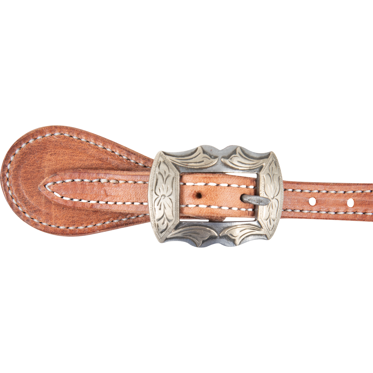 Prescott buckle on a natural harness leather spur strap, seen up close. Engraving covers the scalloped buckle frame, with white stitching on the leather around it.